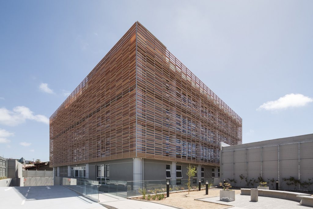 Judicia La Serena Eckansicht eines Gebäudes mit orange-braunen Stangen als Fassade